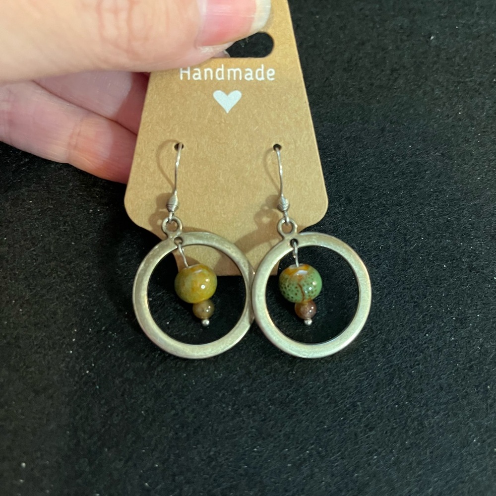 Green with bead surrounded by a circle of silver tone earrings